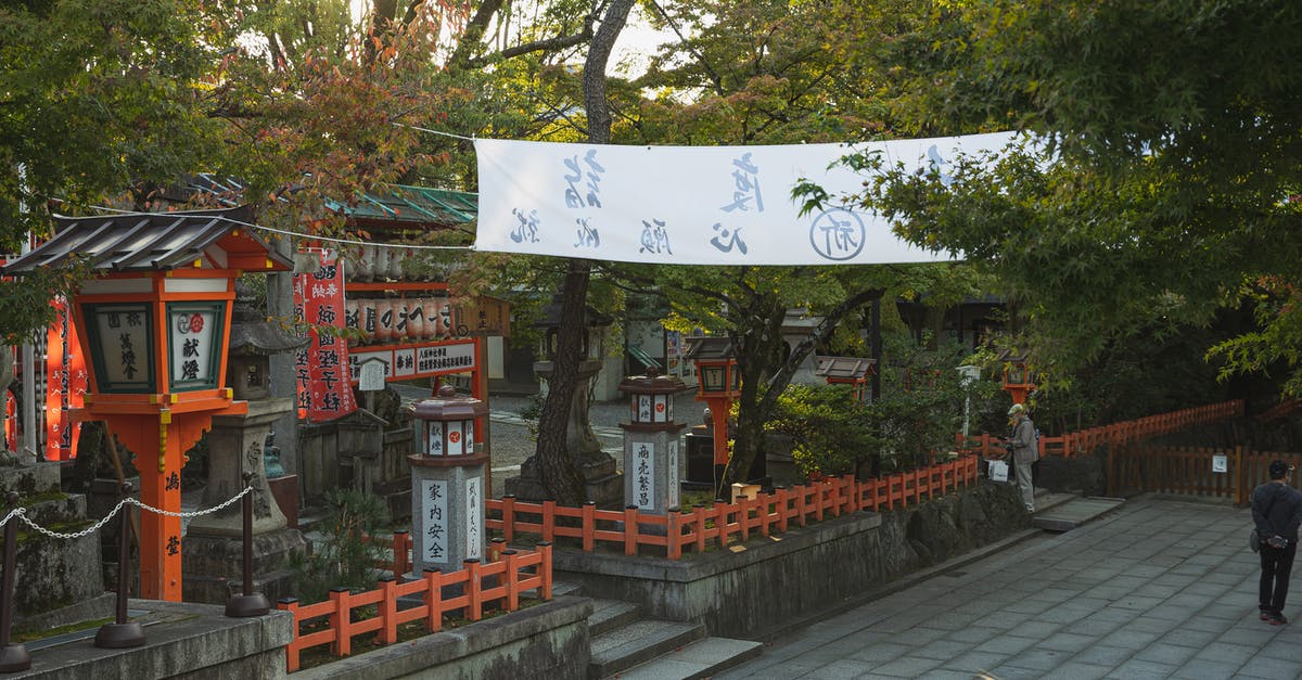 I have an old (1996) felony conviction in Japan and am barred from visiting: Can I transit through there? - From above of building surrounded by lush green tress located on territory of historic Shinto Yasaka Shrine in Kyoto