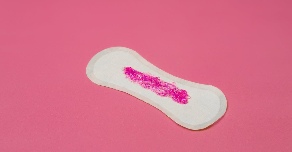 I stayed 3 months over my period in schengen. Can I go back within a month with a new passport? - From above of feminine white hygiene pad with pink paints as symbol of menstruation placed in studio