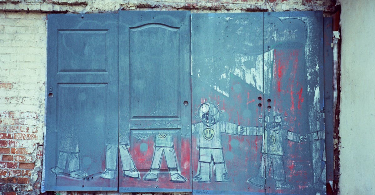 Identify location of old painting - Shabby wooden door with graffiti on weathered stone wall Identify location of old painting - Shabby wooden door with graffiti on weathered stone wall