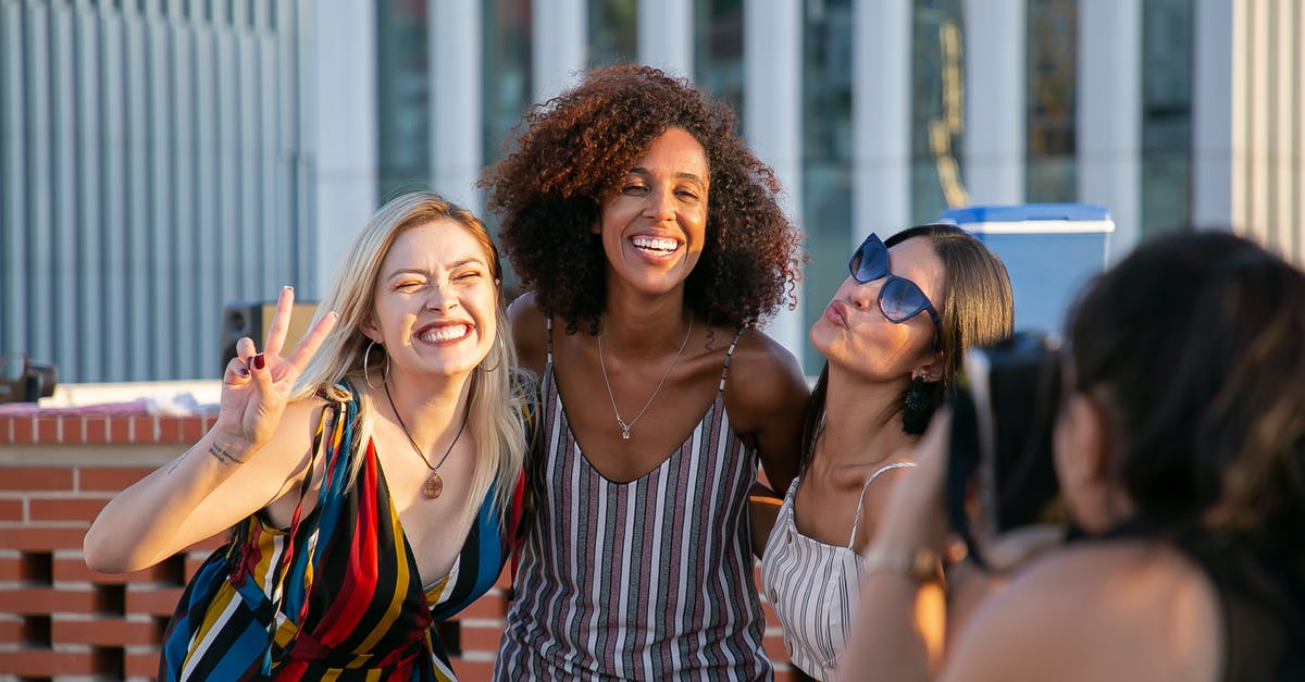 Identify the building in this picture - Unrecognizable female photographer taking picture of cheerful young multiracial female friends smiling and showing V sign during party on modern building rooftop Identify the building in this picture - Unrecognizable female photographer taking picture of cheerful young multiracial female friends smiling and showing V sign during party on modern building rooftop