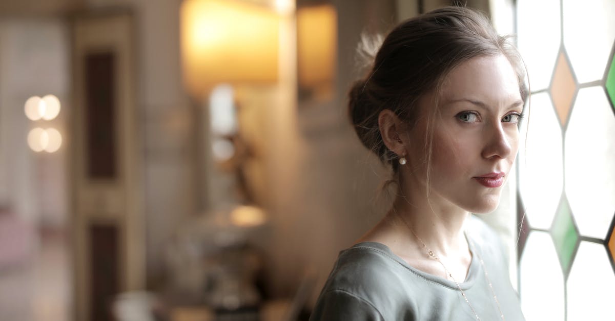 If I don't travel on a UK visit visa and it expires, will it hurt my chances of getting a visa in the future? - Pretty casual serious lady with hairstyle intently looking at camera while standing near stained glass window in bright luxury room of old mansion