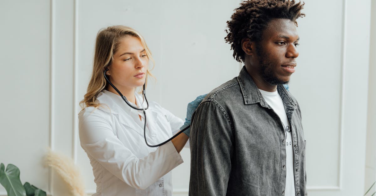If I have an outstanding medical bill in America, can I go back there? [duplicate] - Doctor Checking the Back of a Man