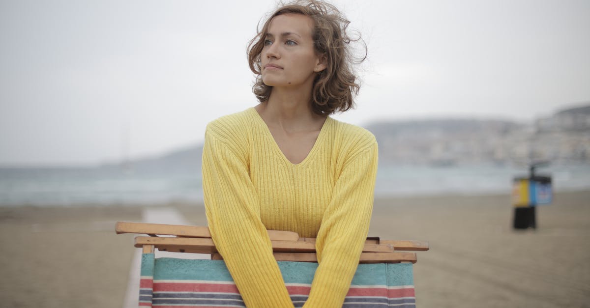 If I miss the outbound in round trip booking, do I use the inbound ticket? - Calm female tourist with folded deckchair standing alone on seashore in overcast weather If I miss the outbound in round trip booking, do I use the inbound ticket? - Calm female tourist with folded deckchair standing alone on seashore in overcast weather