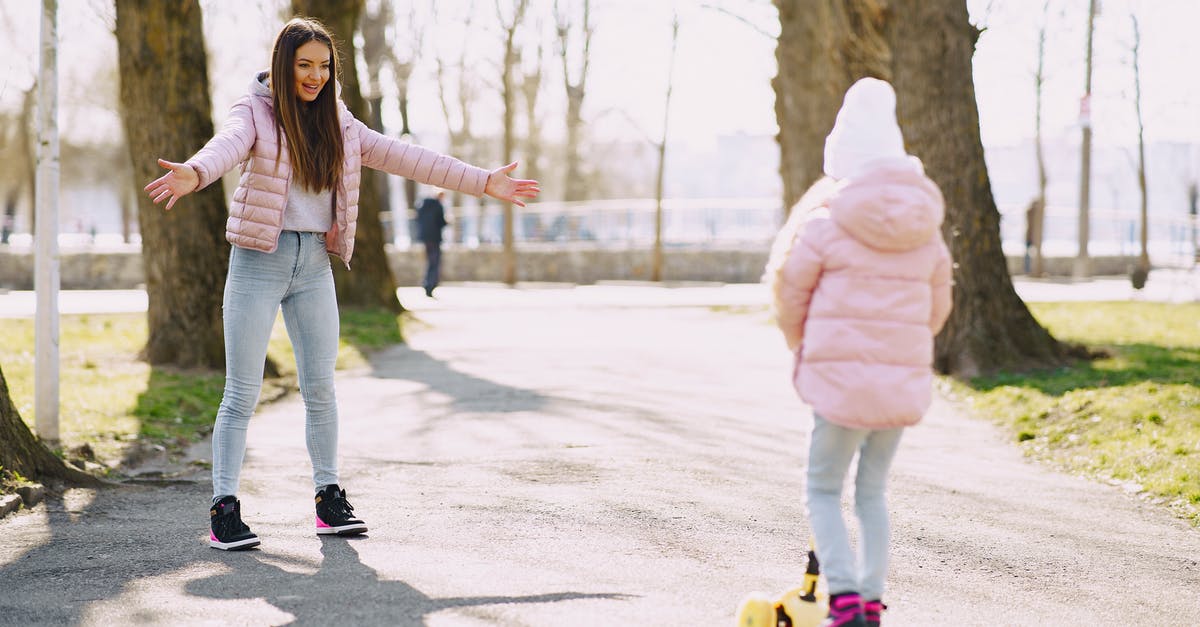 Impact of not having life insurance on sponsoring B2 VISA for parents? - Full body little girl riding kick scooter on alley in park while mother standing with hands apart for support in sunny day