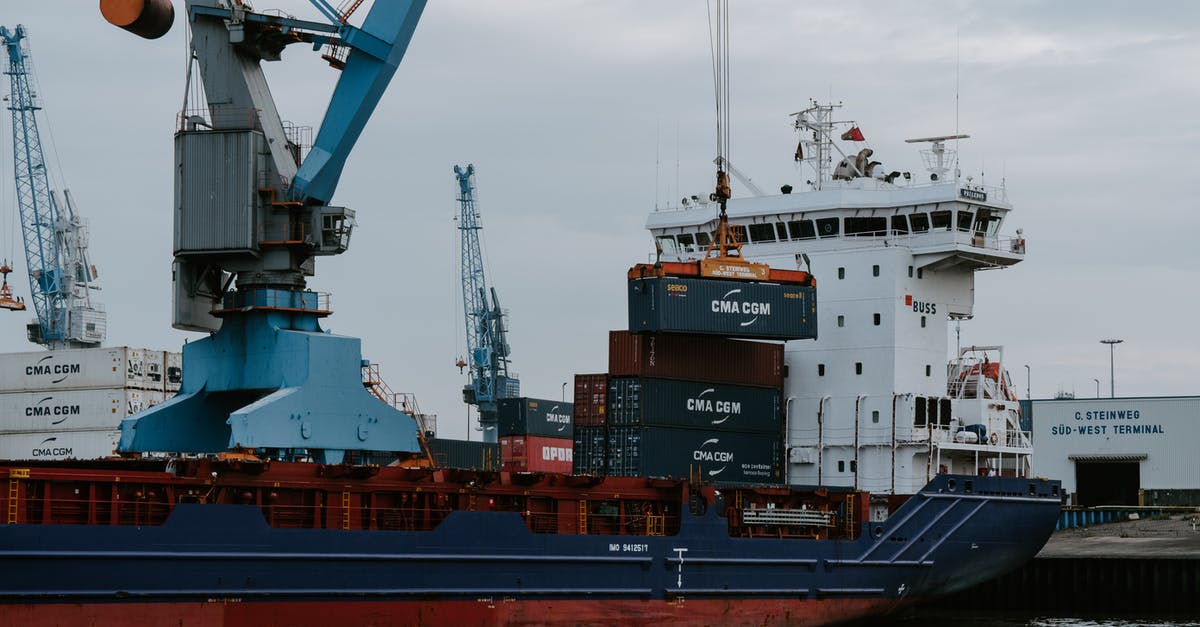 Import of commercial merchandise into the USA in a checked luggage - Blue and Red Cargo Ship With Crane Import of commercial merchandise into the USA in a checked luggage - Blue and Red Cargo Ship With Crane