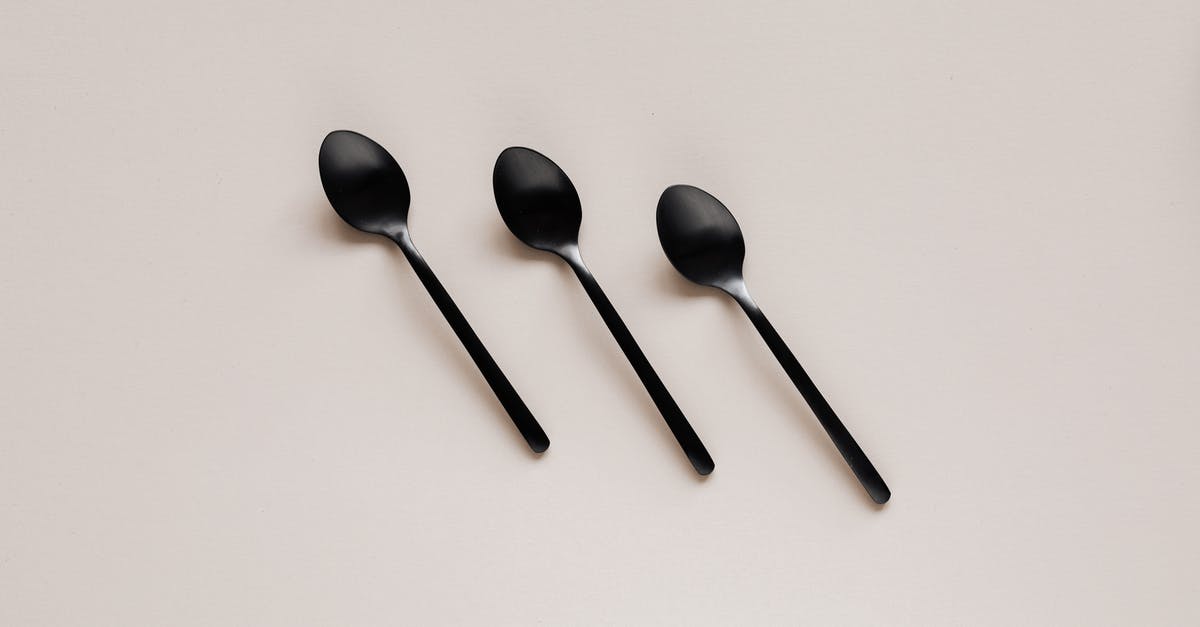 Importing silverware utensil sets to Hong Kong - Set of shiny black spoons on gray table Importing silverware utensil sets to Hong Kong - Set of shiny black spoons on gray table