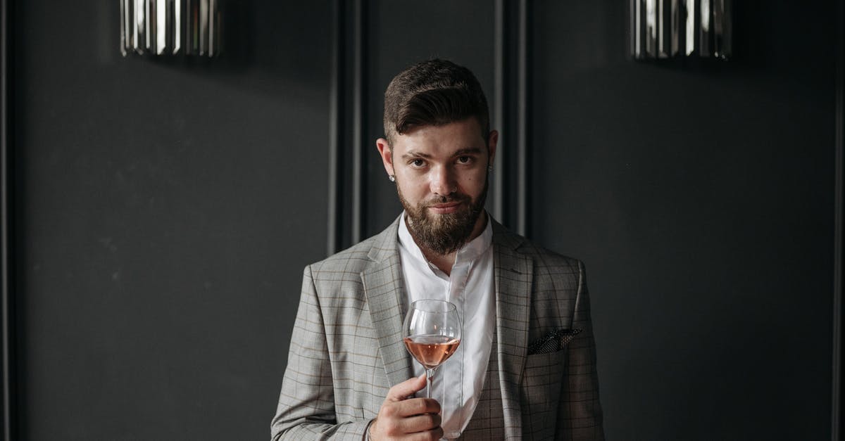 In Belarus, do norms for a work event include informal bar drinks and snacks in the evening? [closed] - Man in Gray Suit Holding Clear Drinking Glass