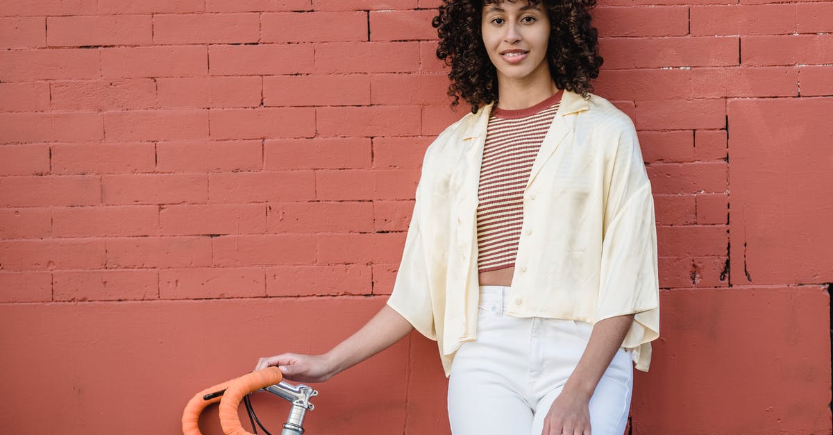In Mongolia, what kind of vehicle is a jeep? - Ethnic woman with bicycle against brick wall In Mongolia, what kind of vehicle is a jeep? - Ethnic woman with bicycle against brick wall