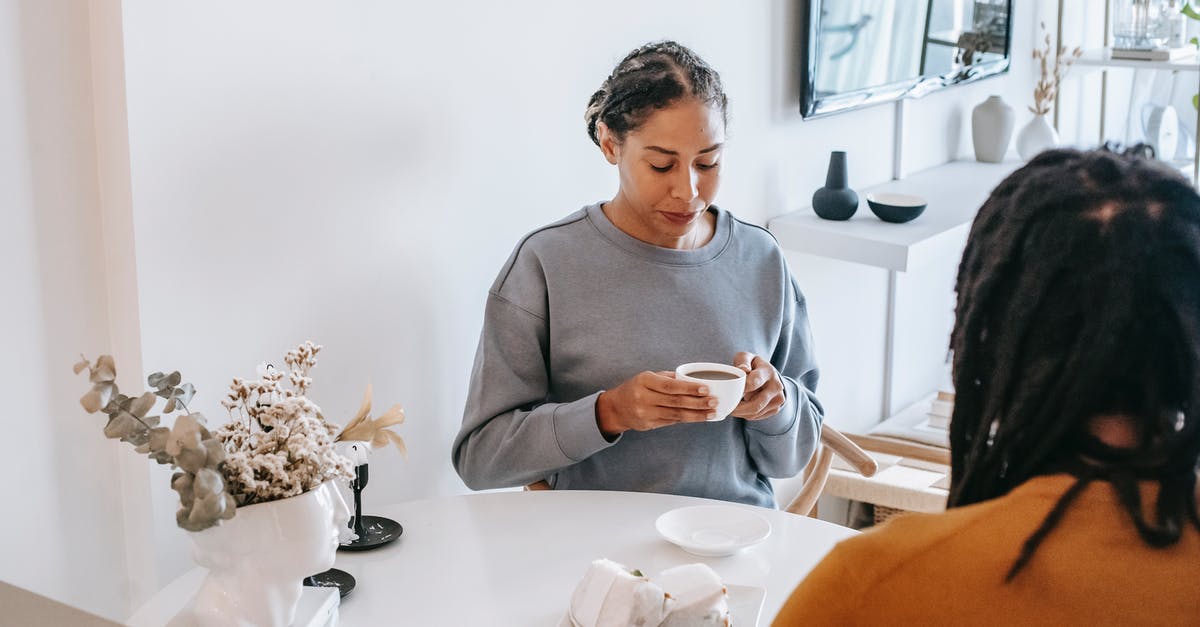 In Schengen visa application, should I include details of my friend who will be spending time with me? - Calm woman drinking coffee with boyfriend at home