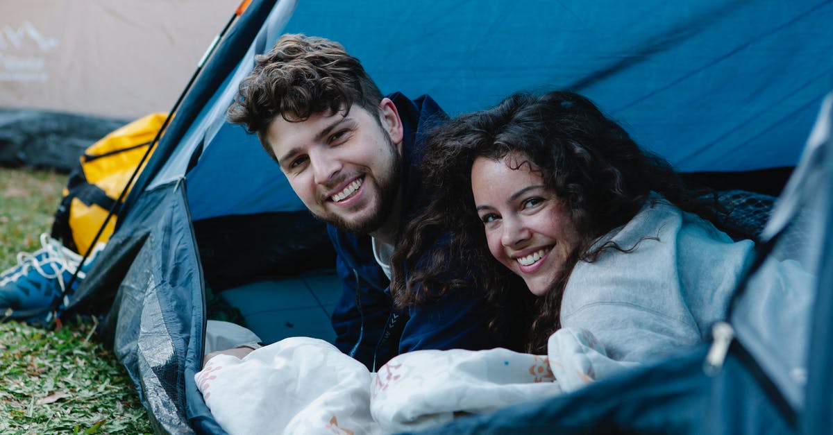In the high season in Ontario, is it possible to camp on campsites without early pre-reservations? - Happy smiling couple resting and smiling in tent In the high season in Ontario, is it possible to camp on campsites without early pre-reservations? - Happy smiling couple resting and smiling in tent