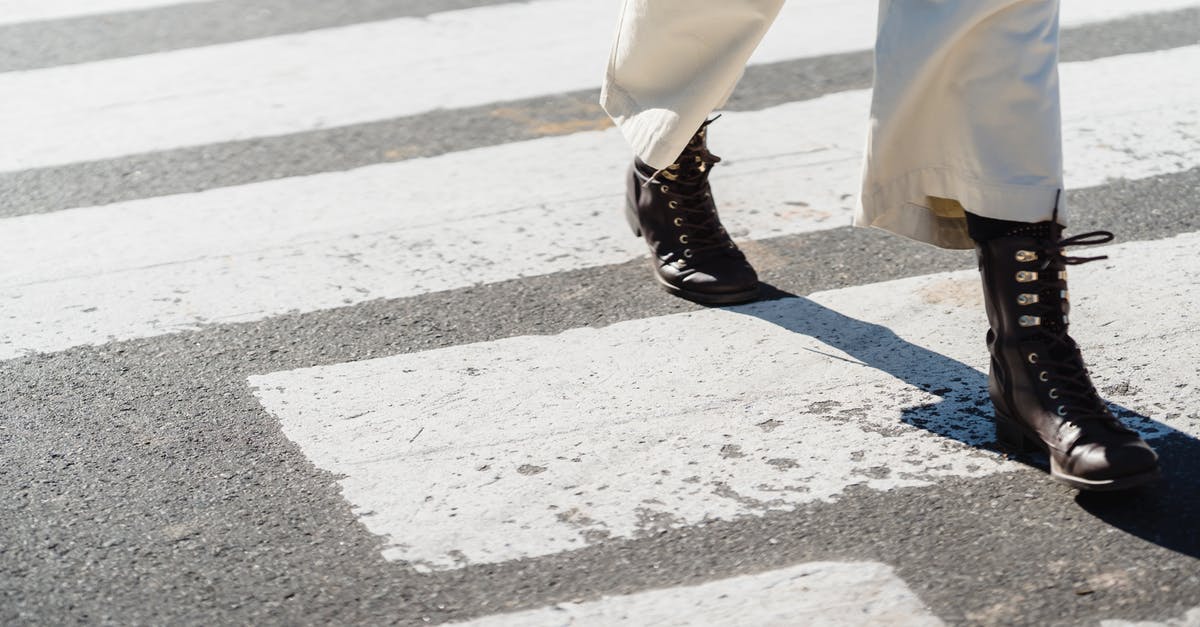 In what states is the left lane only for passing? - Woman crossing asphalt road on zebra In what states is the left lane only for passing? - Woman crossing asphalt road on zebra
