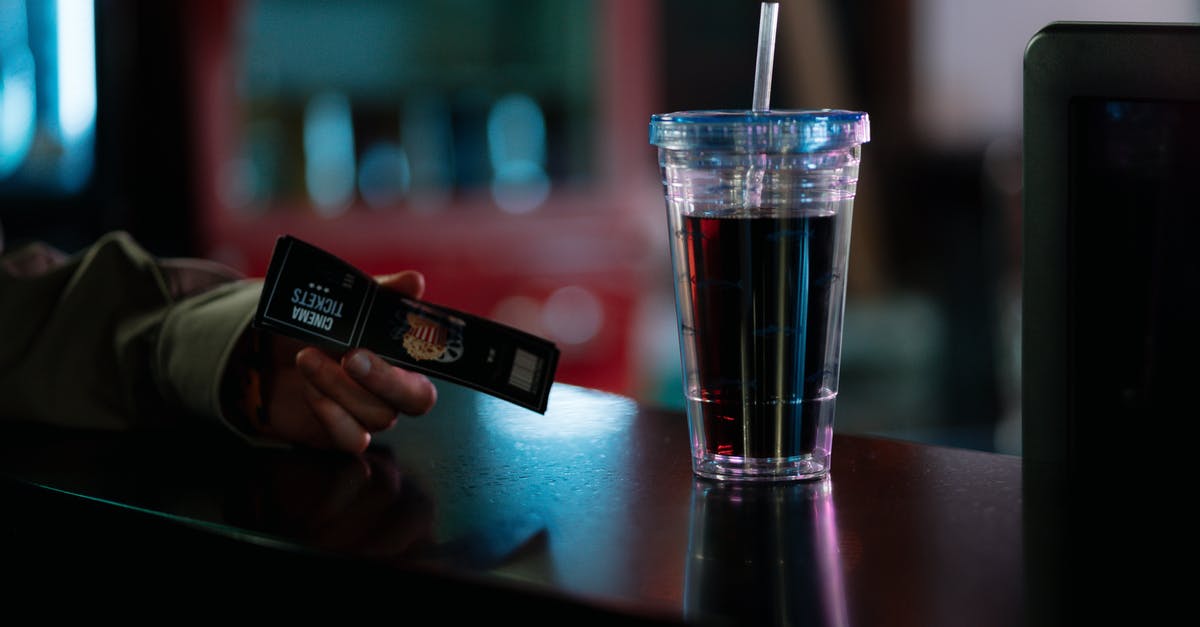 INDIA - Are last minute tickets cheaper at airline ticket counter vs online? [duplicate] - A Person at a Counter with a Cup of Beverage Holding Cinema Ticket