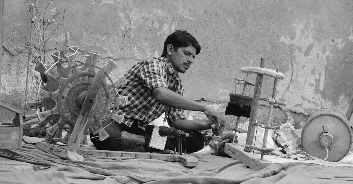 Indian eVisa Process - Serious ethnic man weaving textile on street Indian eVisa Process - Serious ethnic man weaving textile on street