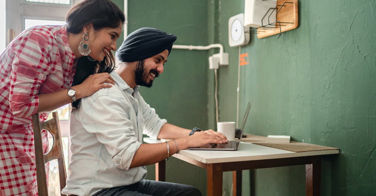 Indian Passport back cover torn a bit. Can it get accepted? [duplicate] - Side view of cheerful adult couple in casual outfit using netbook at table in kitchen while woman bending over man touching back
