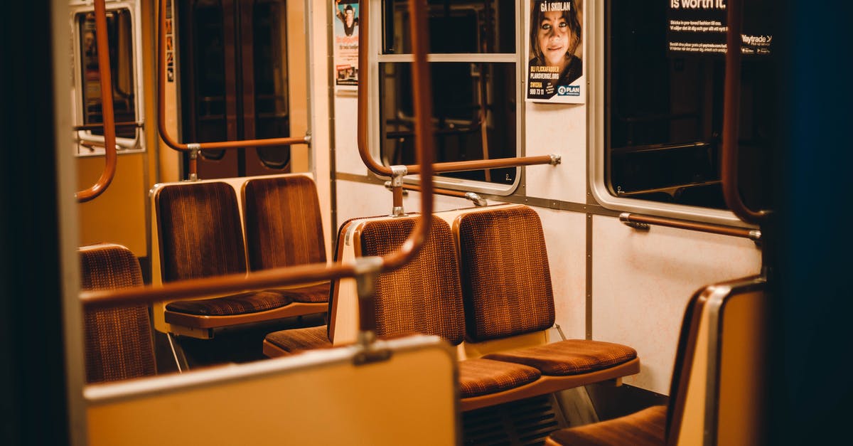 Indian Trains Wait List - will I get a seat? - Interior of empty subway train with metal railing and seats near big windows Indian Trains Wait List - will I get a seat? - Interior of empty subway train with metal railing and seats near big windows