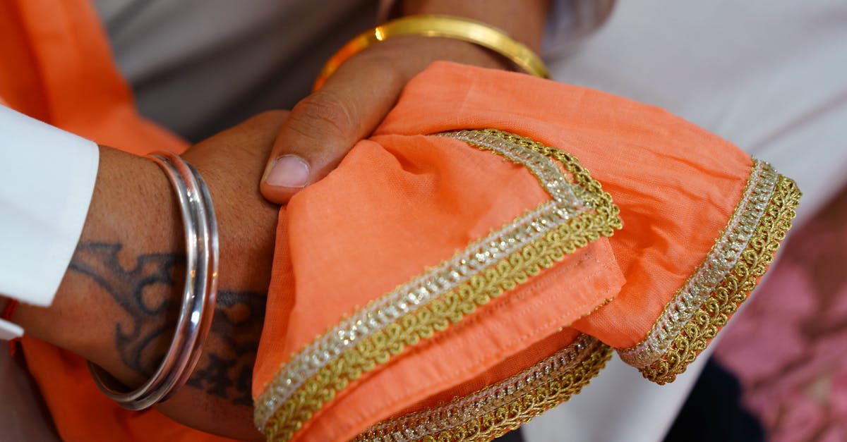 Indian visa with Bangladeshi origins - Crop unrecognizable Indian groom wearing traditional white wedding clothes and pink scarf with embroidery sitting with hands clasped Indian visa with Bangladeshi origins - Crop unrecognizable Indian groom wearing traditional white wedding clothes and pink scarf with embroidery sitting with hands clasped