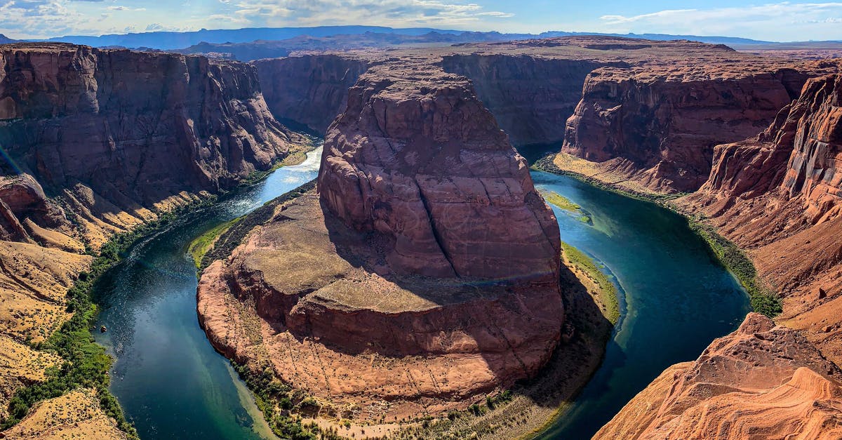 Inner tubing down rivers in the United States - Brown Rock Formation Near Body of Water Inner tubing down rivers in the United States - Brown Rock Formation Near Body of Water