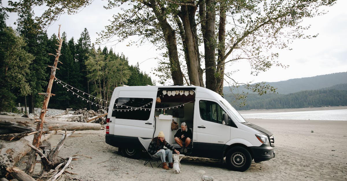 Insurance for campervan in NZ - Man and Woman Sitting on White Van Near Green Trees Insurance for campervan in NZ - Man and Woman Sitting on White Van Near Green Trees