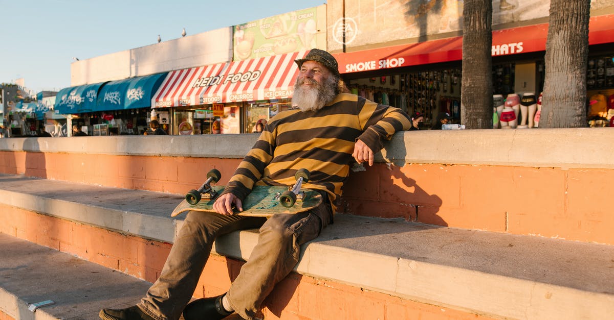 Intercity transportation in Cuba - Man in Green and Brown Stripe Long Sleeve Shirt Sitting on Brown Concrete Bench Intercity transportation in Cuba - Man in Green and Brown Stripe Long Sleeve Shirt Sitting on Brown Concrete Bench