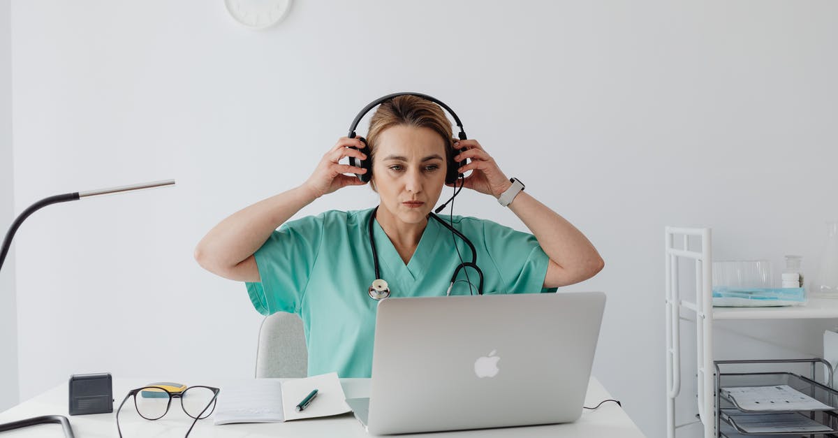 Internet in Japan - A Woman in Teal Shirt Sitting Near the Table with Laptop while Wearing a Headset