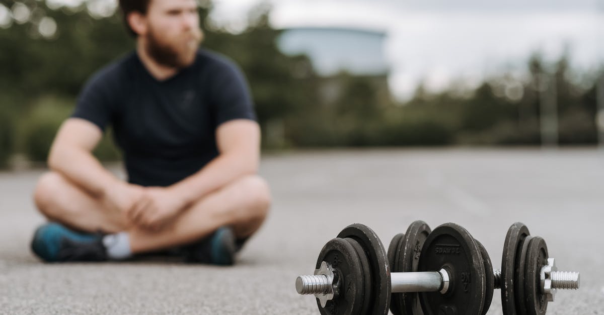 Is 16 days enough to self-drive the whole Iceland ring road in September, and fit in activities? [closed] - Young male with beard resting after workout on asphalt road with heavy dumbbells on gloomy day in selective focus