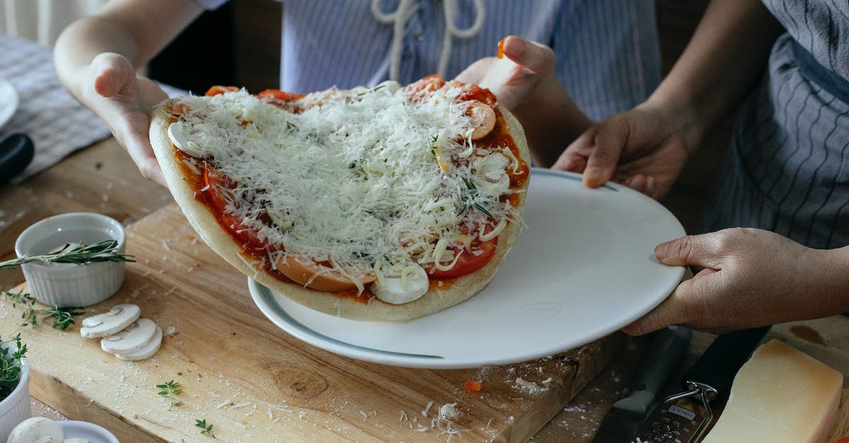 Is 1h10m enough time to transfer at Dublin airport? - High angle of crop anonymous women transferring uncooked yummy homemade pizza on platter during preparation to baking in kitchen