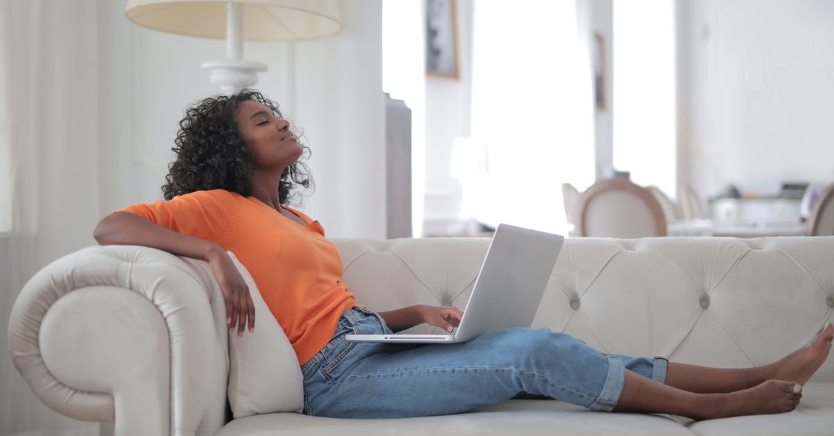 Is a 17-inch (wide) / 30-inch (pitch) seat comfortable for a long-haul flight? [closed] - Woman in Orange Top and Blue Denim Jeans Sitting on White Sofa Using Macbook