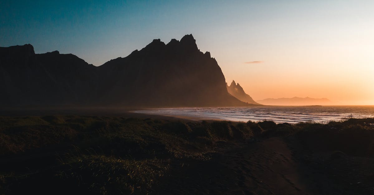 Is a 4x4 a must in Iceland in April/May? - Silhouette of Mountain Near Body of Water during Sunset Is a 4x4 a must in Iceland in April/May? - Silhouette of Mountain Near Body of Water during Sunset