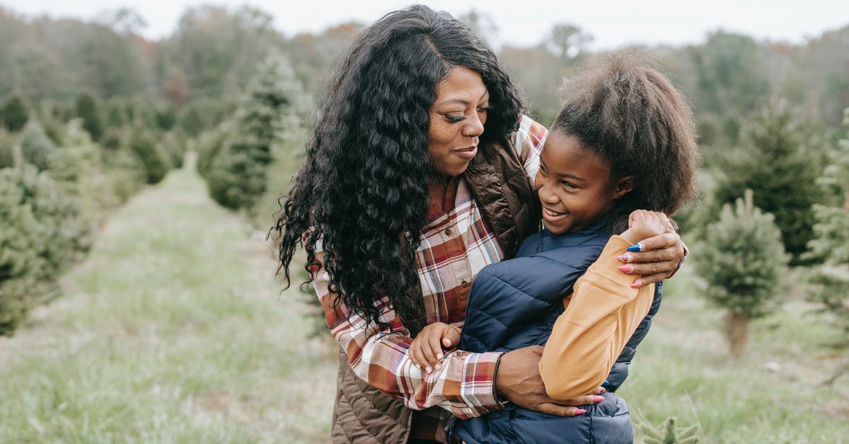 Is a 54 minute layover in Chicago O’Hare in December with a child enough? - Cheerful African American mum cuddling child while standing close among rows of Christmas trees Is a 54 minute layover in Chicago O’Hare in December with a child enough? - Cheerful African American mum cuddling child while standing close among rows of Christmas trees