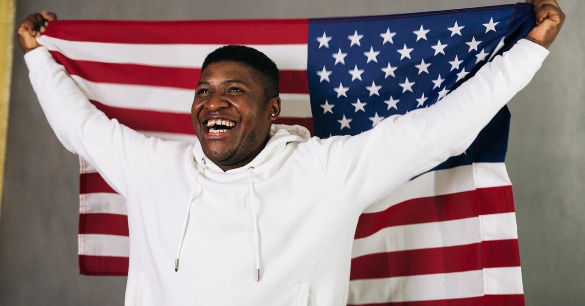 Is a visa needed for a stopover in USA for a person holding a Canadian permanent resident visa? [duplicate] - Close-Up Photo of a Man in a White Hoodie Holding a United States of America Flag