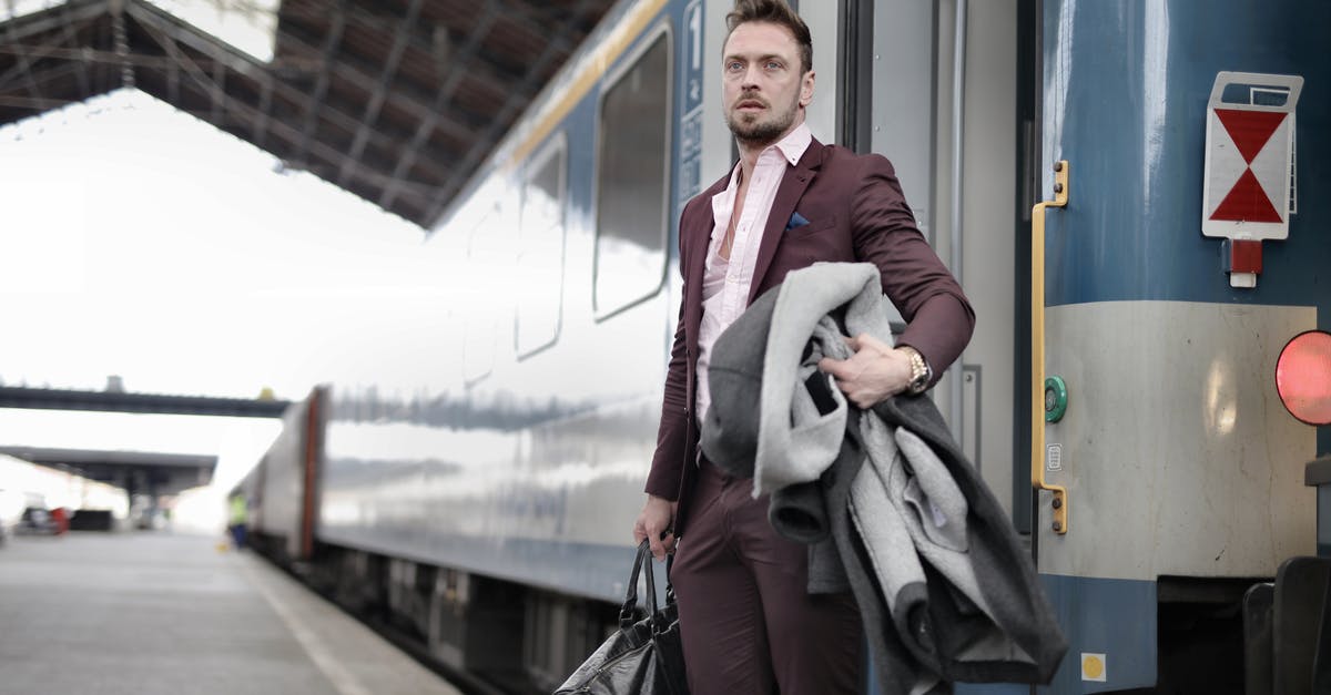 Is airside transit available at Tocumen airport, Panama? - Serious stylish bearded businessman in trendy suit holding bag and coat in hands standing near train on platform in railway station and looking away Is airside transit available at Tocumen airport, Panama? - Serious stylish bearded businessman in trendy suit holding bag and coat in hands standing near train on platform in railway station and looking away