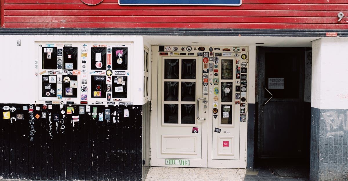 Is brushing your teeth in the public toilet a culture specific activity? [closed] - Exterior of closed pub with blue sign above entrance decorated with graffiti and colorful stickers