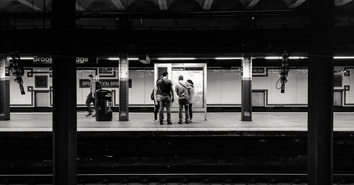 Is Colmar's railway station next to the city center? - Black and white of anonymous people waiting for train on platform of subway station Is Colmar's railway station next to the city center? - Black and white of anonymous people waiting for train on platform of subway station