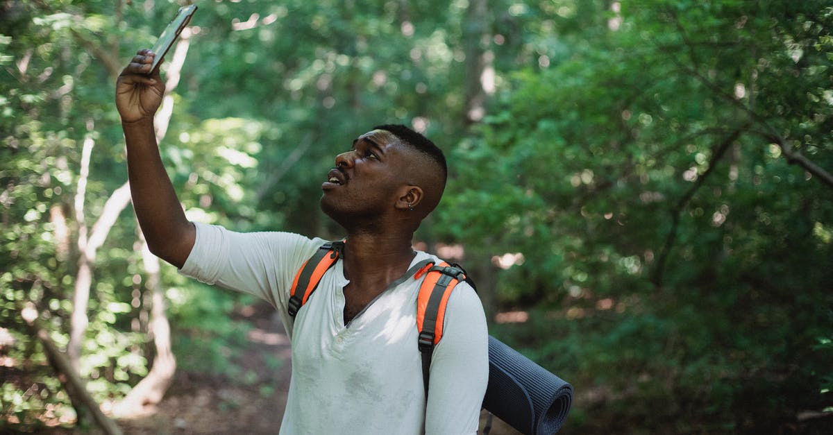 Is hiking up Ben Nevis doable with a fear of heights? - African American male with backpack standing in forest and holding mobile phone while catching GPS signal during hike Is hiking up Ben Nevis doable with a fear of heights? - African American male with backpack standing in forest and holding mobile phone while catching GPS signal during hike