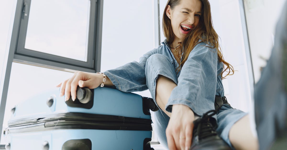 Is it a must to have your flight ticket when applying for a visa? - Low angle of young exited female traveler with suitcase in stylish outfit having fun before flight Is it a must to have your flight ticket when applying for a visa? - Low angle of young exited female traveler with suitcase in stylish outfit having fun before flight