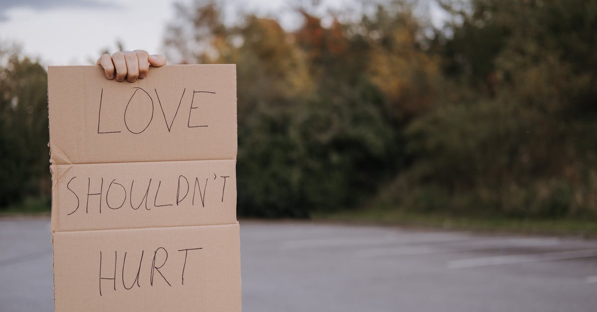Is it a problem for wrong gender on flight tickets? - Crop anonymous person demonstrating carton signboard with slogan love should not hurt on blurred background of asphalt road and trees Is it a problem for wrong gender on flight tickets? - Crop anonymous person demonstrating carton signboard with slogan love should not hurt on blurred background of asphalt road and trees