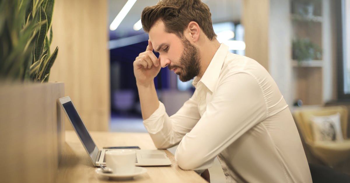 Is it a problem if my laptop is out of battery when I'm asked to switch it on? - Man With Hand on Temple Looking at Laptop Is it a problem if my laptop is out of battery when I'm asked to switch it on? - Man With Hand on Temple Looking at Laptop