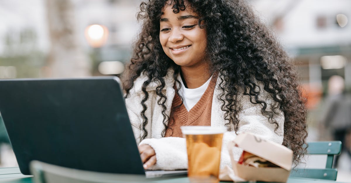 Is it acceptable to bring your own food to beer gardens in Prague? - Smiling black woman using laptop in city park Is it acceptable to bring your own food to beer gardens in Prague? - Smiling black woman using laptop in city park