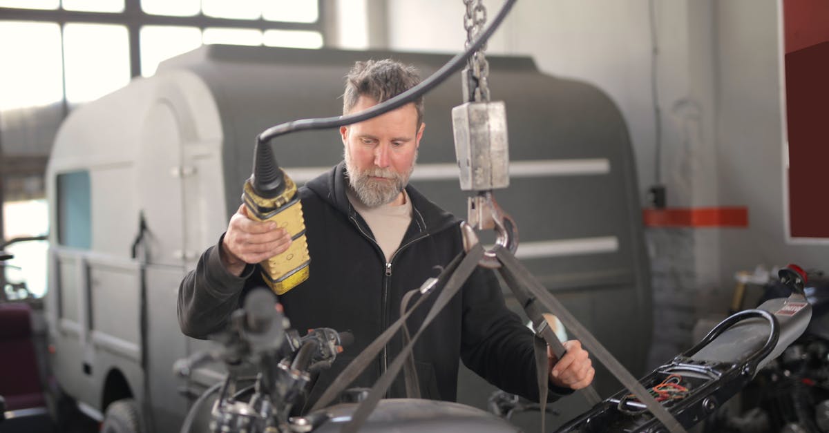 Is it allowed and advisable to transport beer in checked luggage? [duplicate] - Male mechanic using hydraulic crane in garage