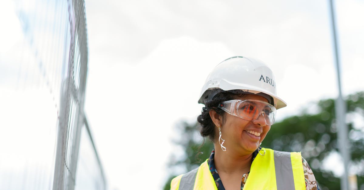 Is it allowed to wear a bulletproof vest in Hong Kong? [closed] - Photo Of Female Engineer Wearing Hard Hat And Yellow Vest 