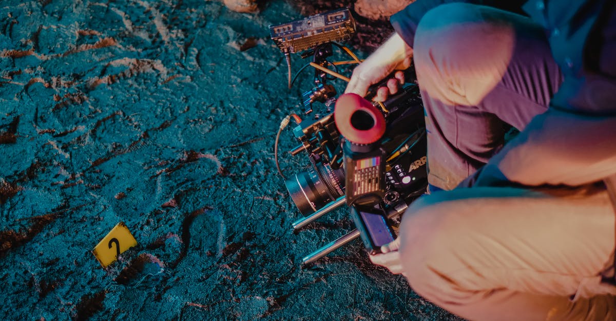 Is it illegal to watch violent films on an airplane? - High angle of crop unrecognizable investigators with professional equipment photographing evidence at crime scene Is it illegal to watch violent films on an airplane? - High angle of crop unrecognizable investigators with professional equipment photographing evidence at crime scene