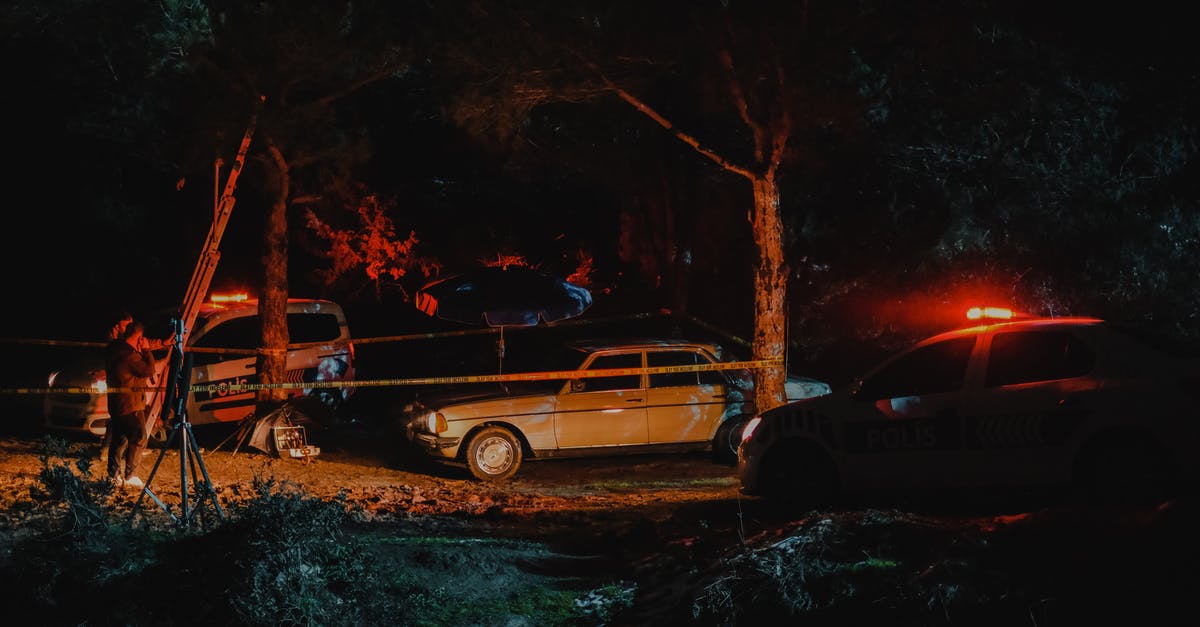 Is it illegal to watch violent films on an airplane? - Investigators from police working on crime scene fenced with caution tape in woods at night Is it illegal to watch violent films on an airplane? - Investigators from police working on crime scene fenced with caution tape in woods at night