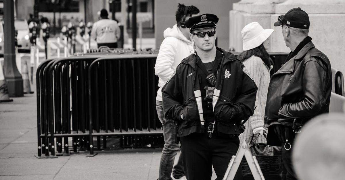 Is it legal in Spain for a male airport security guard to ask you to lift up your blouse and swab your bare stomach? - Man Wearing Jacket and Peaked Cap Grayscale Photo