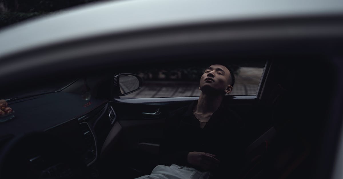 Is it legal to sleep in a parked car on the streets of Munich? - Through window of relaxed young Asian guy in casual clothes lying in modern car with closed eyes in evening Is it legal to sleep in a parked car on the streets of Munich? - Through window of relaxed young Asian guy in casual clothes lying in modern car with closed eyes in evening