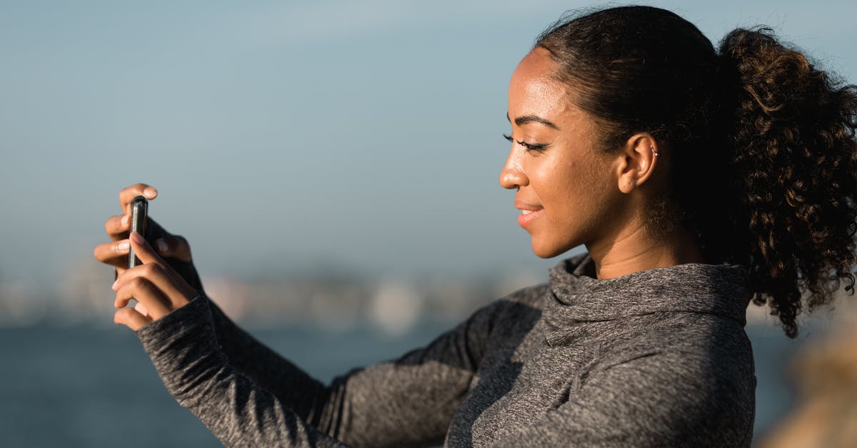 Is it legal to take photos at the airport? - Side View of a Woman Taking Pictures with her Smartphone Is it legal to take photos at the airport? - Side View of a Woman Taking Pictures with her Smartphone