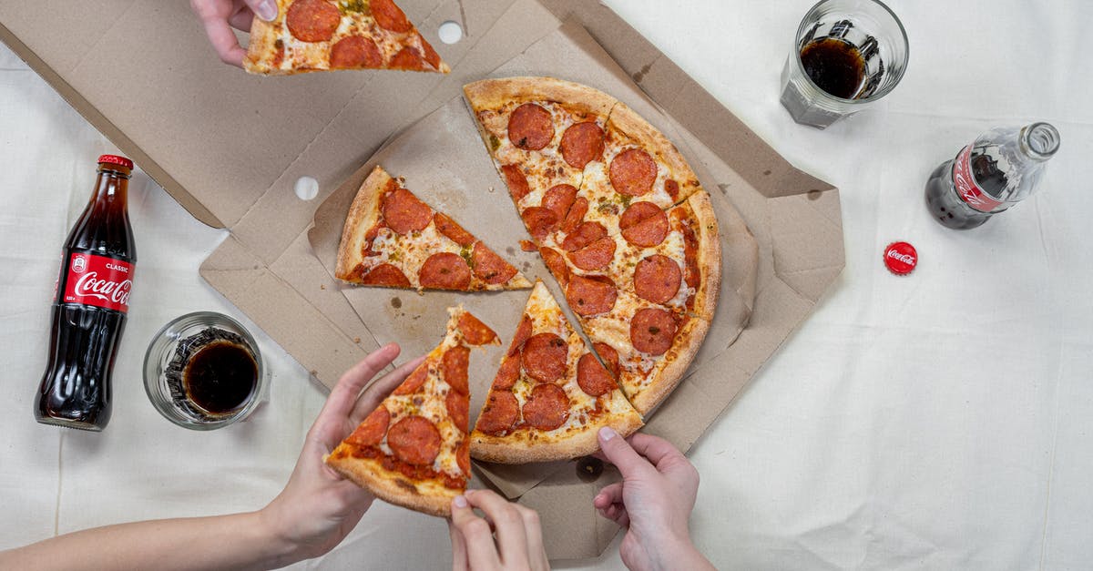 Is it not appropriate to eat pizza with hands in Germany? - Person Holding Pizza on White Box Is it not appropriate to eat pizza with hands in Germany? - Person Holding Pizza on White Box