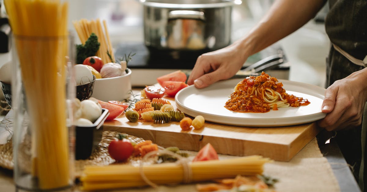 Is it offensive to the chef/host to finish all food on your plate in Italy? - Crop anonymous cook standing at table with various ingredients and cooking pasta with meat and tomatoes Is it offensive to the chef/host to finish all food on your plate in Italy? - Crop anonymous cook standing at table with various ingredients and cooking pasta with meat and tomatoes