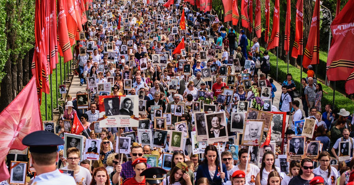 Is it okay for holiday-makers to enter the United Kingdom with a single ticket? - Parade of People Walking Together Carrying Banners with Pictures Is it okay for holiday-makers to enter the United Kingdom with a single ticket? - Parade of People Walking Together Carrying Banners with Pictures