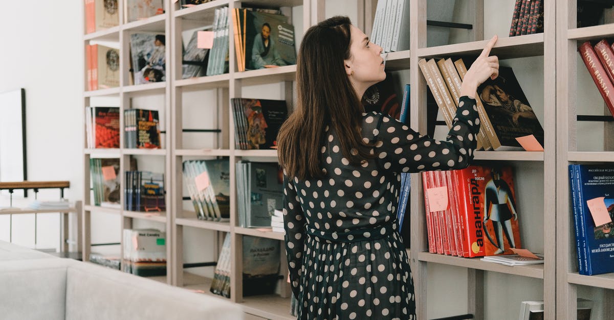 Is it possible to aggregate different hotel bookings in one search? - Young woman choosing book from bookshelf Is it possible to aggregate different hotel bookings in one search? - Young woman choosing book from bookshelf