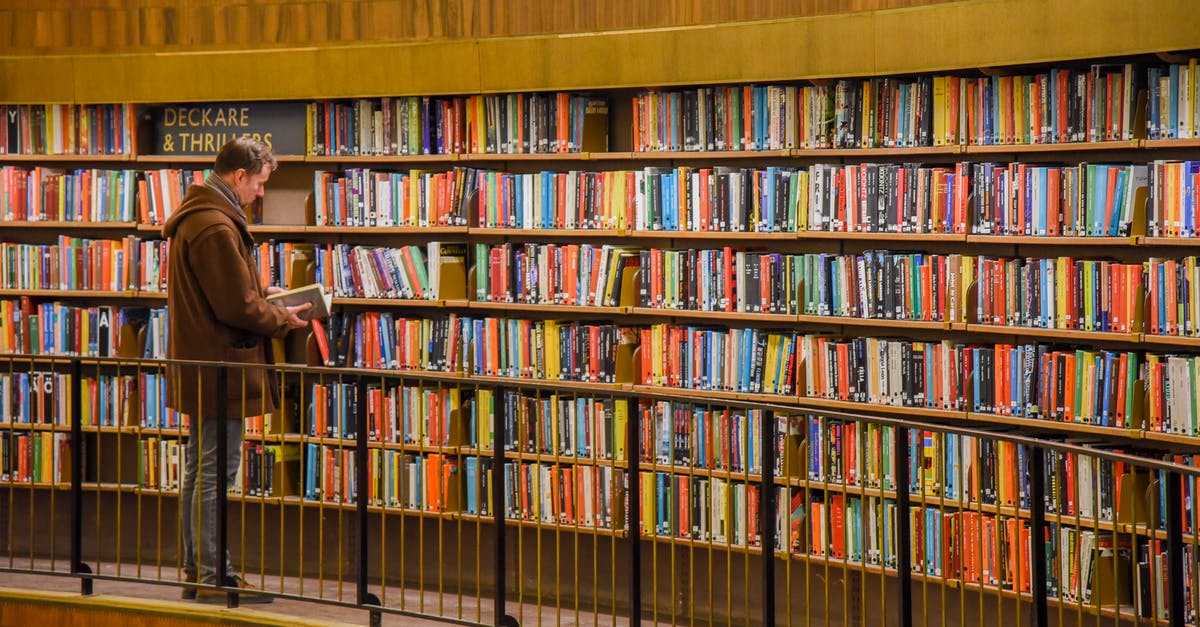 Is it possible to aggregate different hotel bookings in one search? - Side view of anonymous male standing near bookshelves with collection of colorful books in city library Is it possible to aggregate different hotel bookings in one search? - Side view of anonymous male standing near bookshelves with collection of colorful books in city library